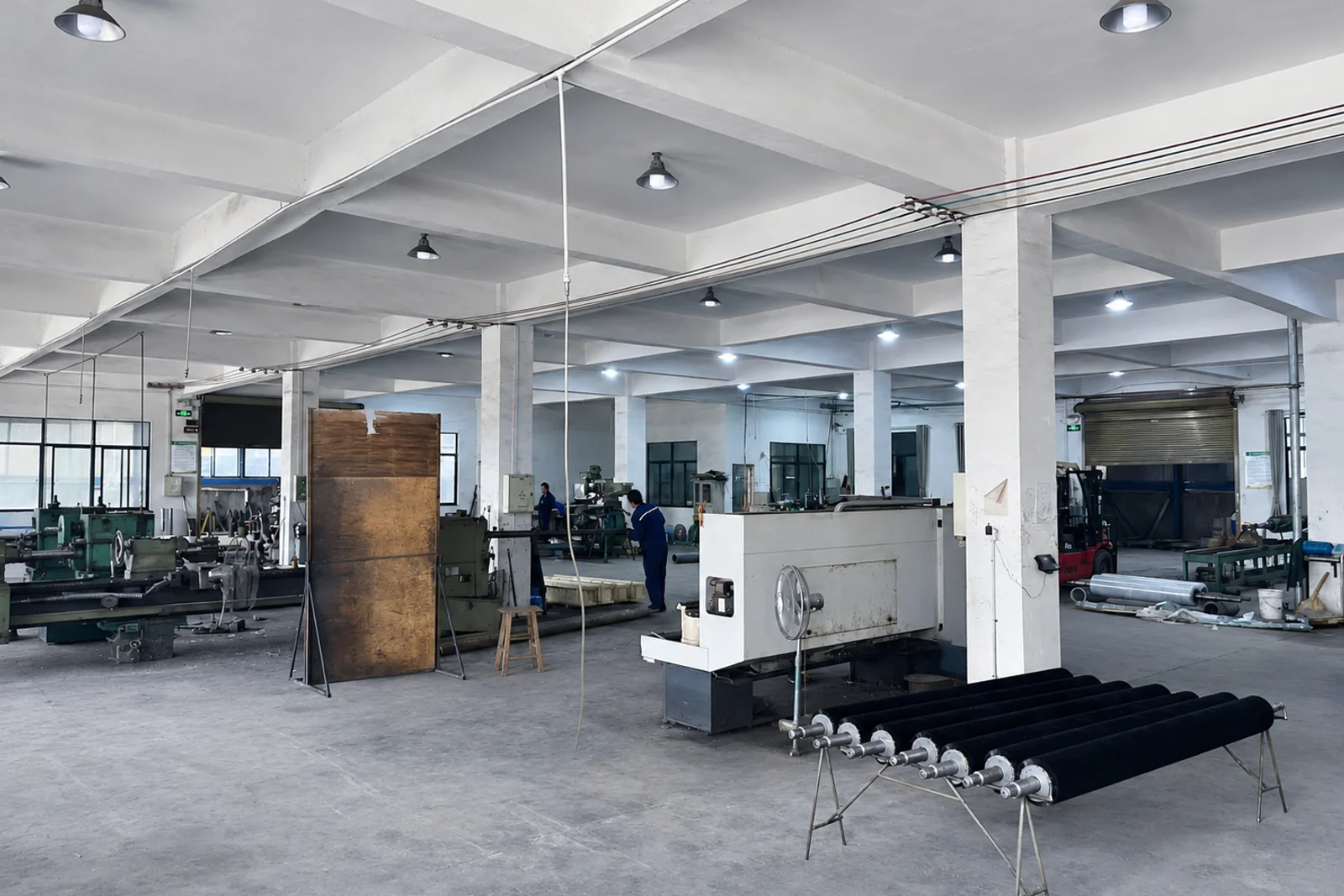 Production workshop with industrial roller brushes and manufacturing equipment