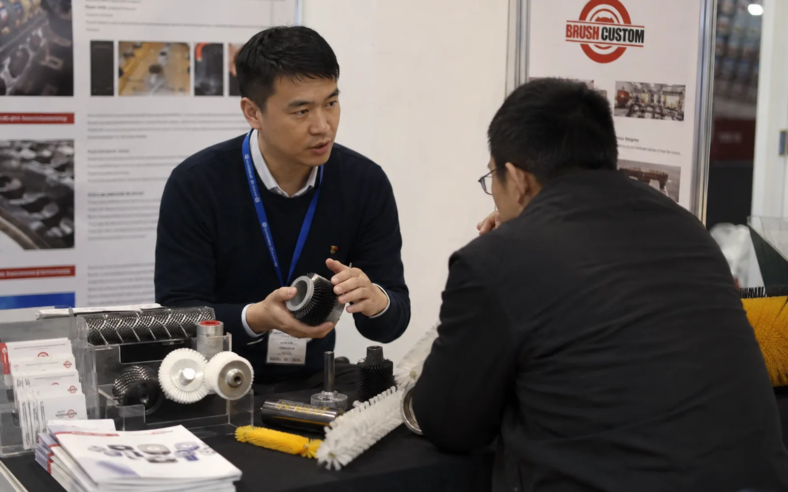 Brushcustom representative discussing brush requirements with a customer at a trade show