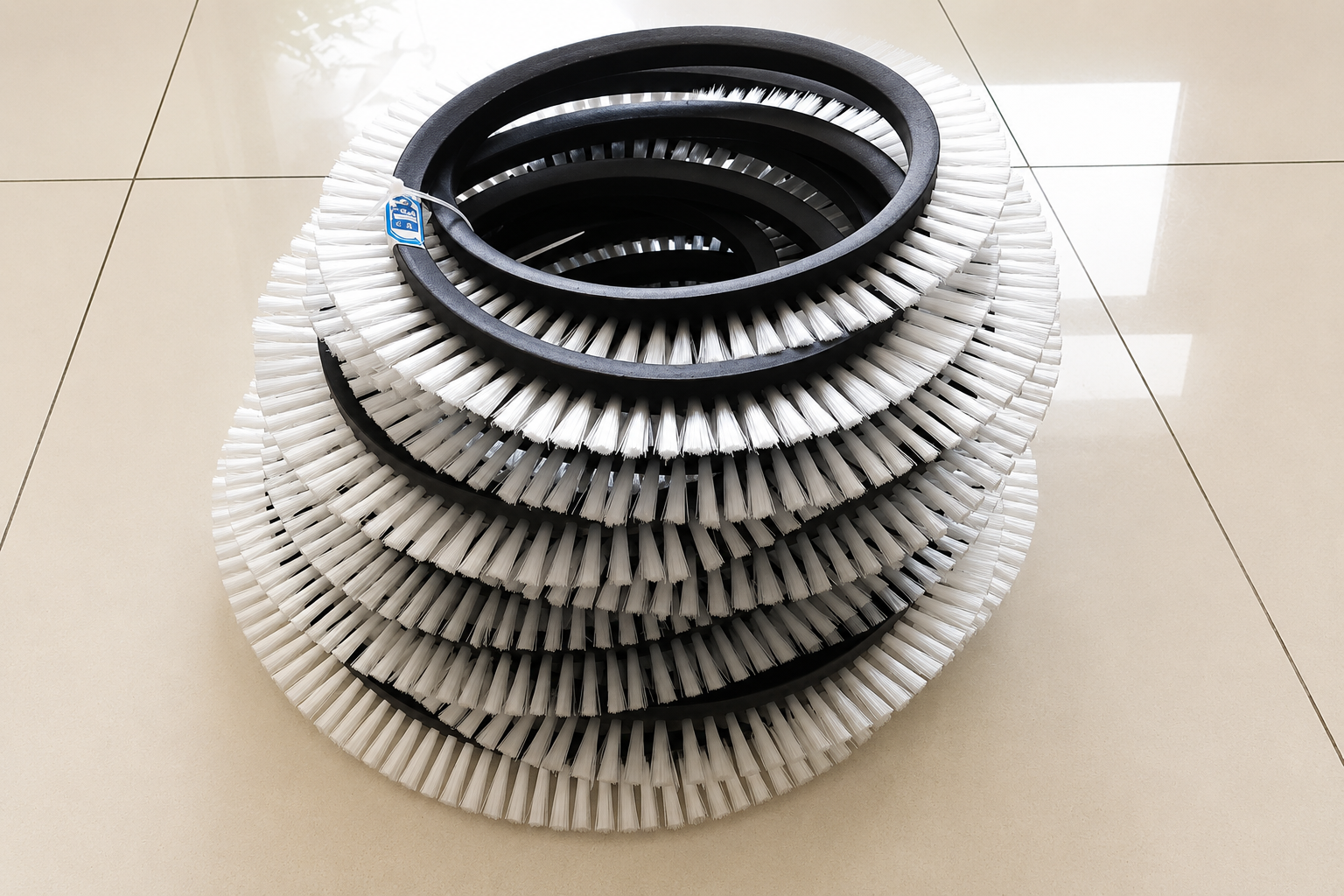 Custom belt brush manufacturer assembly with tufted filaments
