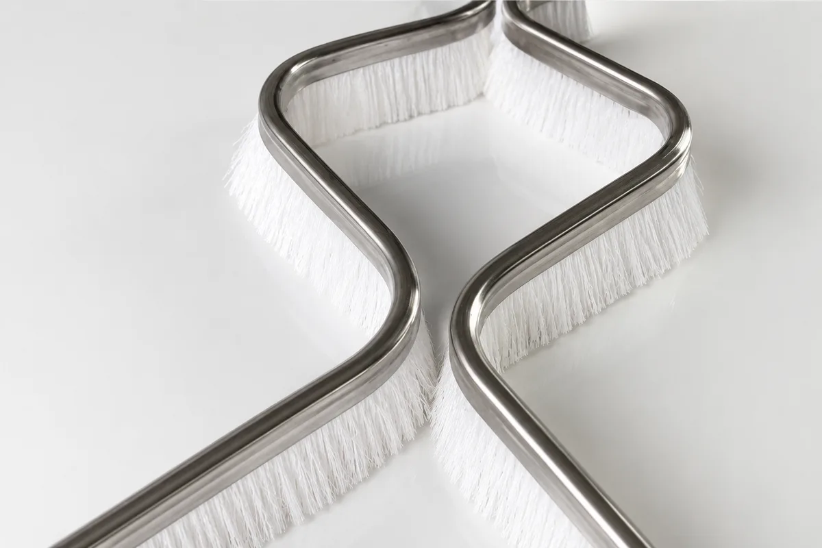 Formed PBT channel strip brushes used in dry ski slope mats