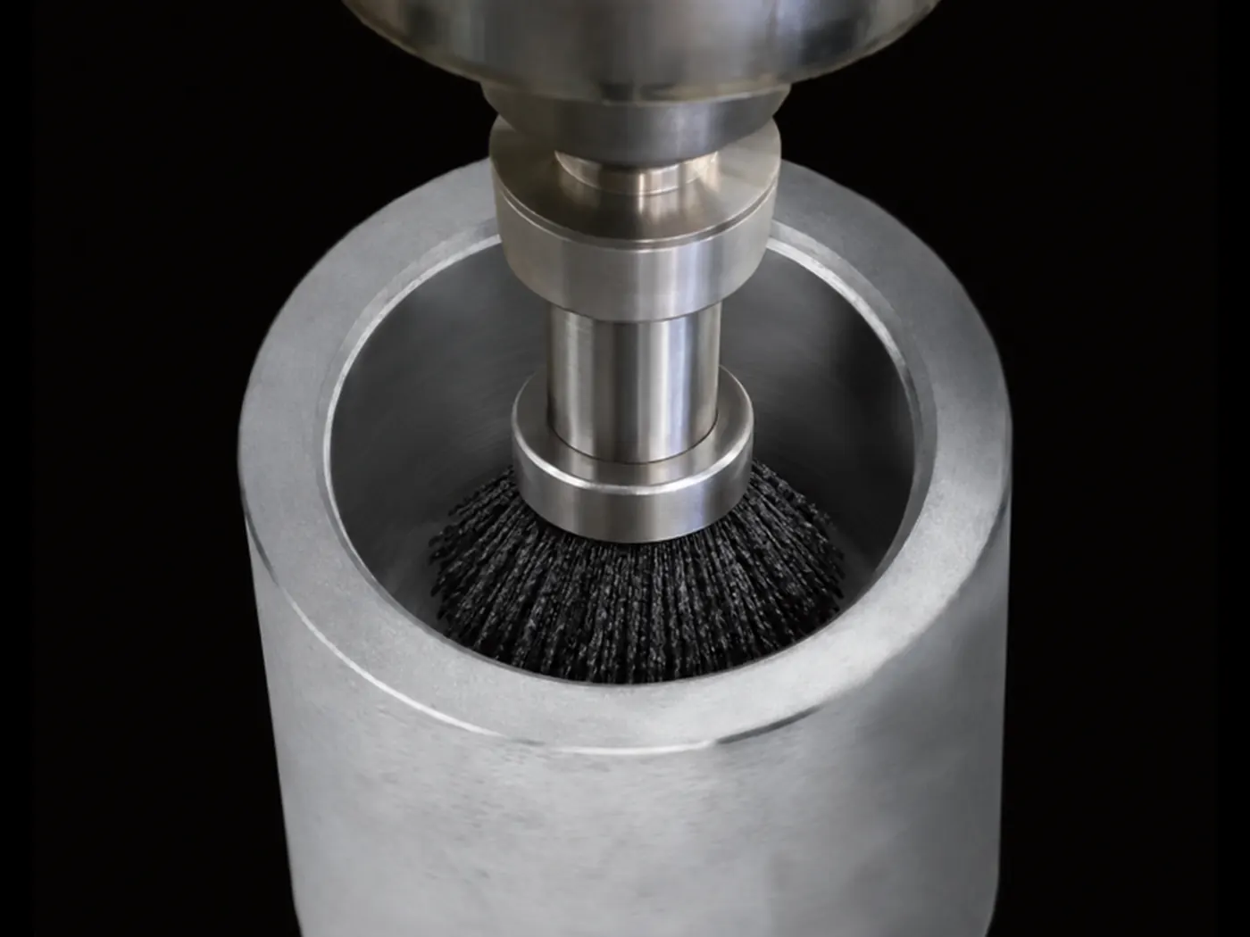 Internal bore finishing brush working inside an aerospace hydraulic component