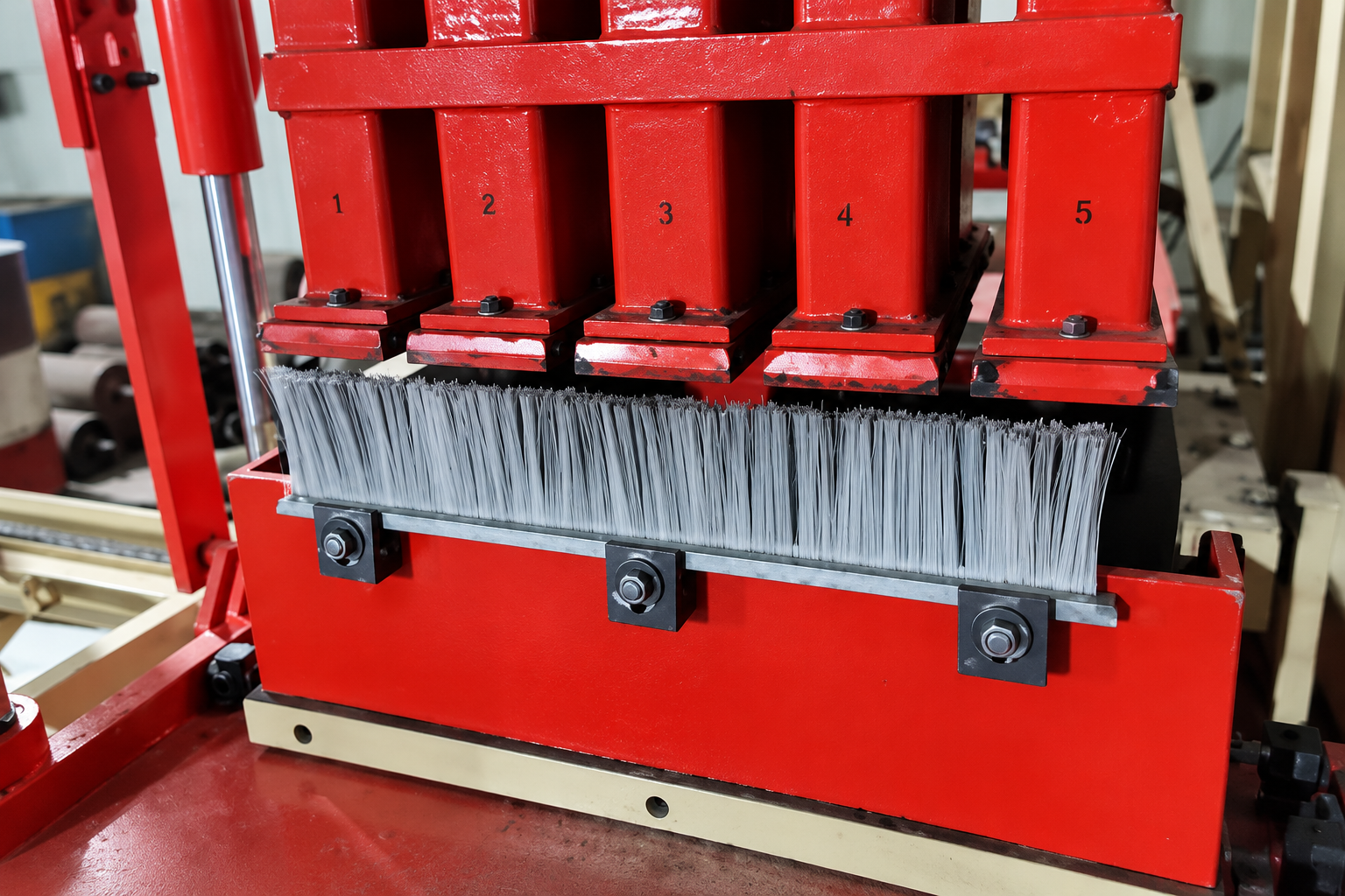 Feed drawer strip brush mounted beneath tamper components on a concrete block machine