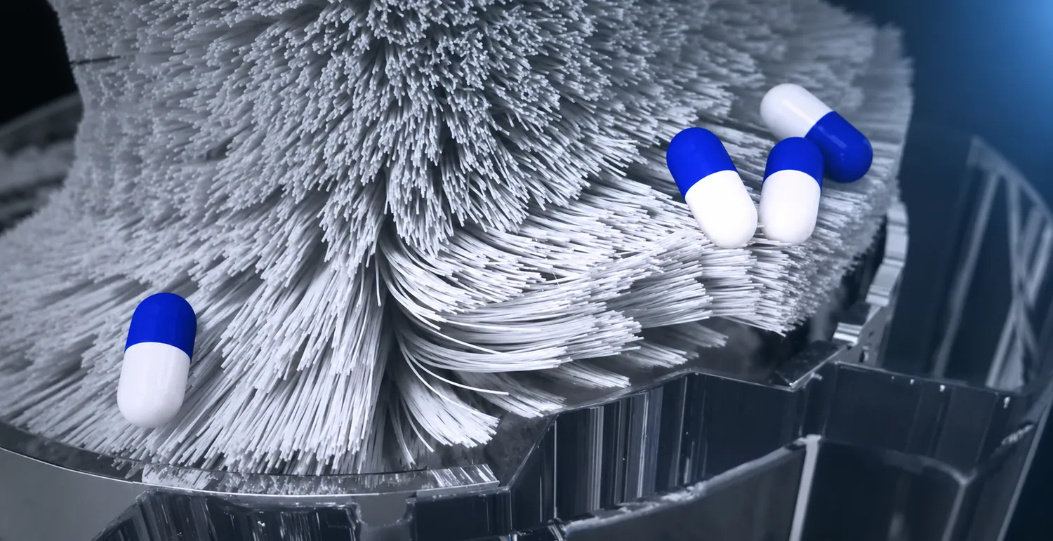 Capsules moving across a dense white polishing brush surface