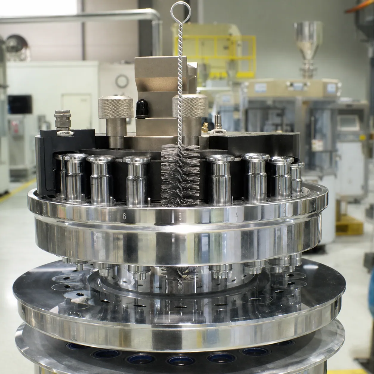 Small cleaning brush positioned inside pharmaceutical processing equipment for maintenance cleaning
