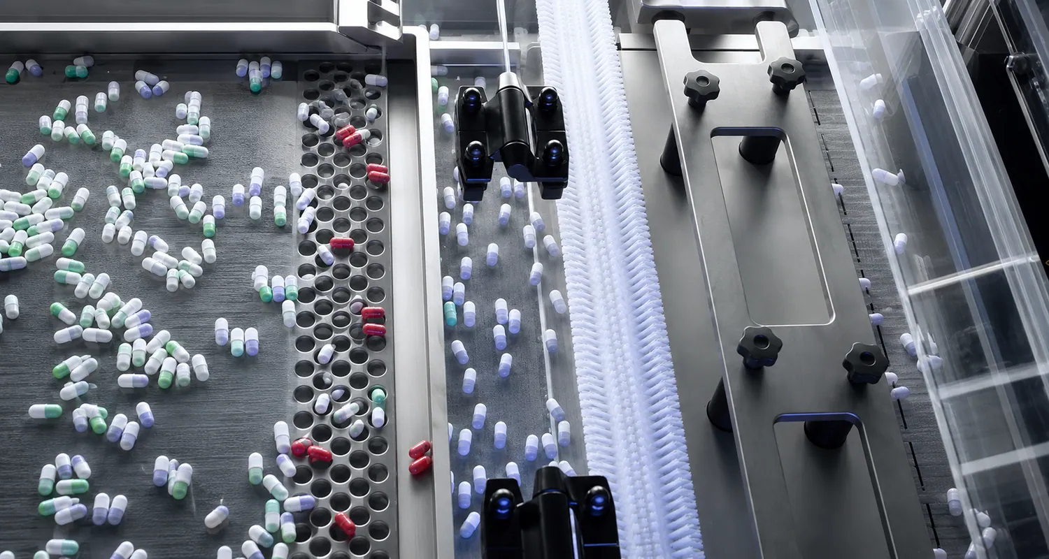 Capsule inspection and sorting conveyor with brush guidance before packaging