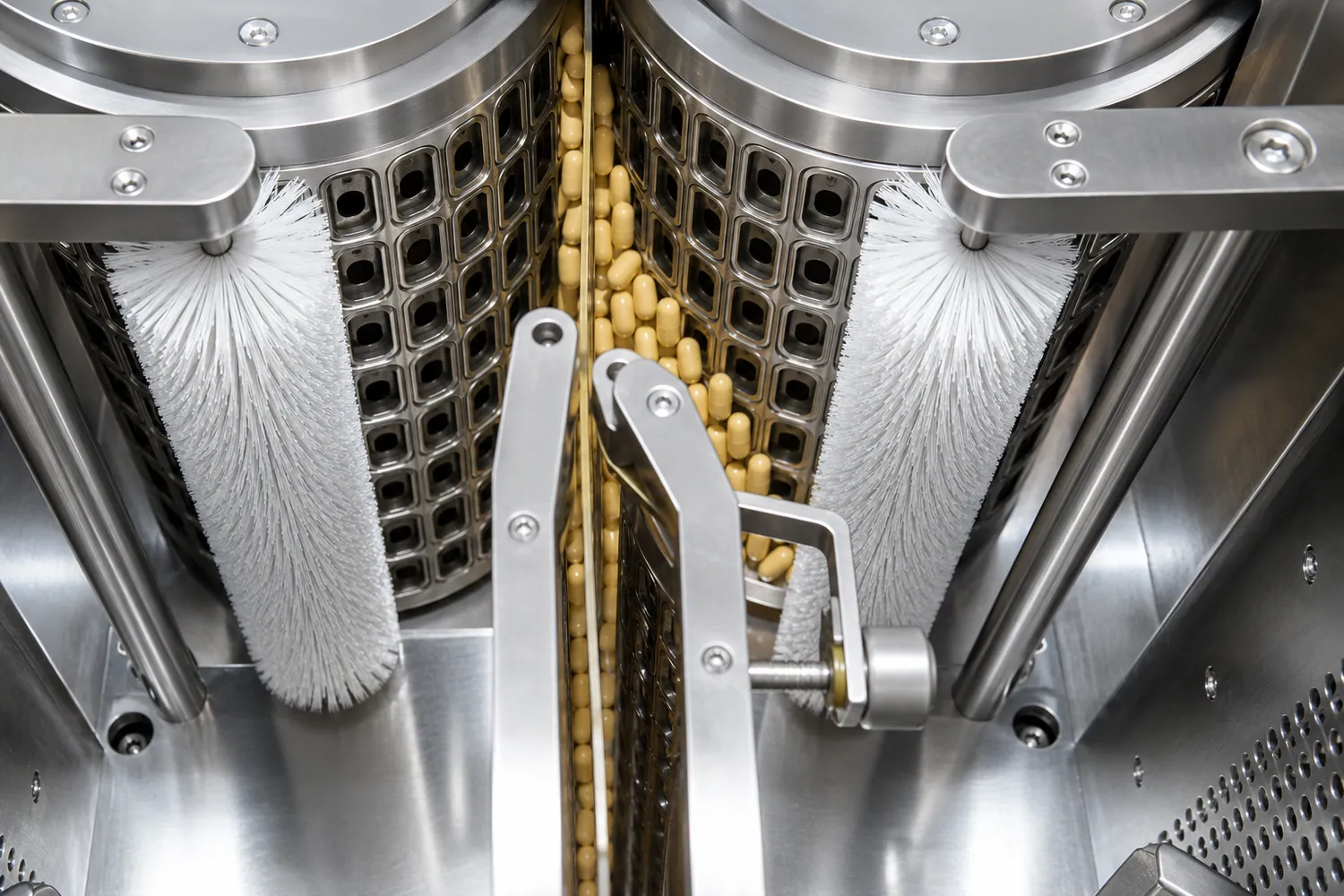 White roller brushes guiding capsules inside pharmaceutical handling equipment