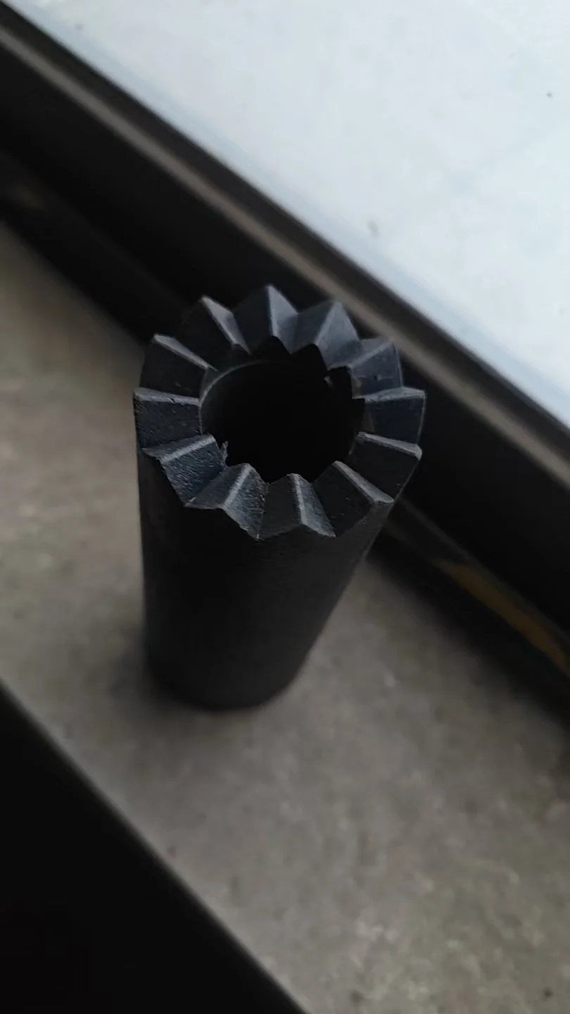 Black 12-tooth zig-zag segment-body sample showing the center bore and toothed end profile