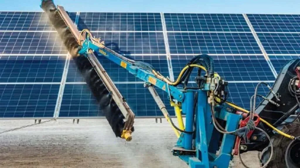 Rotating solar panel cleaning brushes working across a utility scale photovoltaic installation